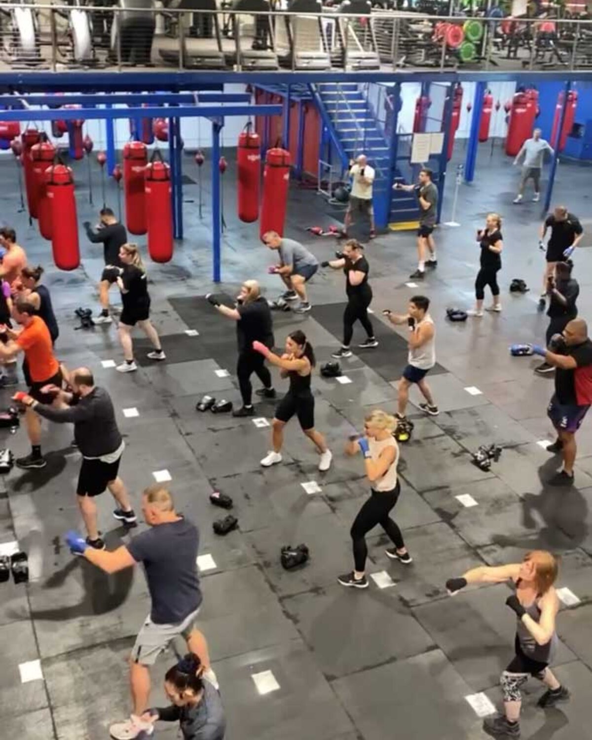 A packed BoxingFit group class throwing punches on the gym floor