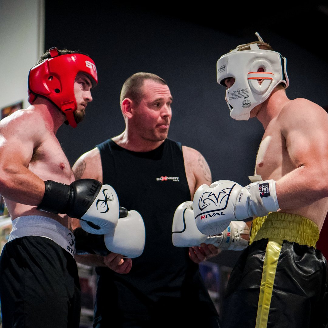 Coach instructing two boxers before sparring